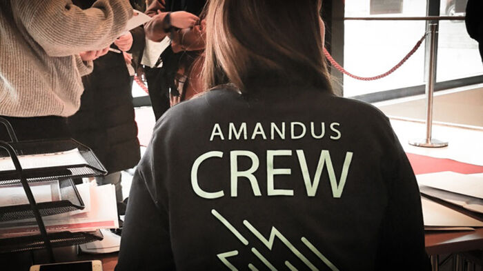 Bilde av person med jakke med teksten AMandus Crew