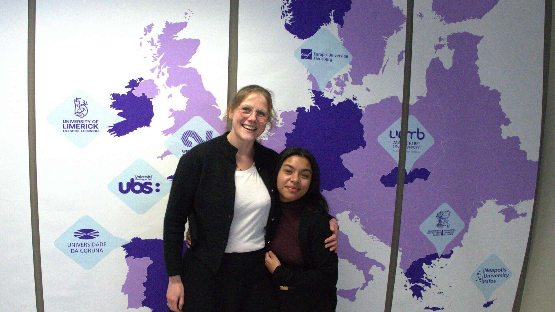 Two persons in front of a European map