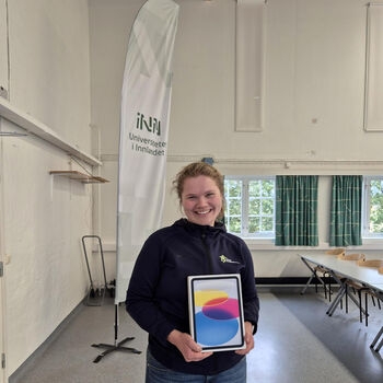 Student i mørke klær som holder en iPad.