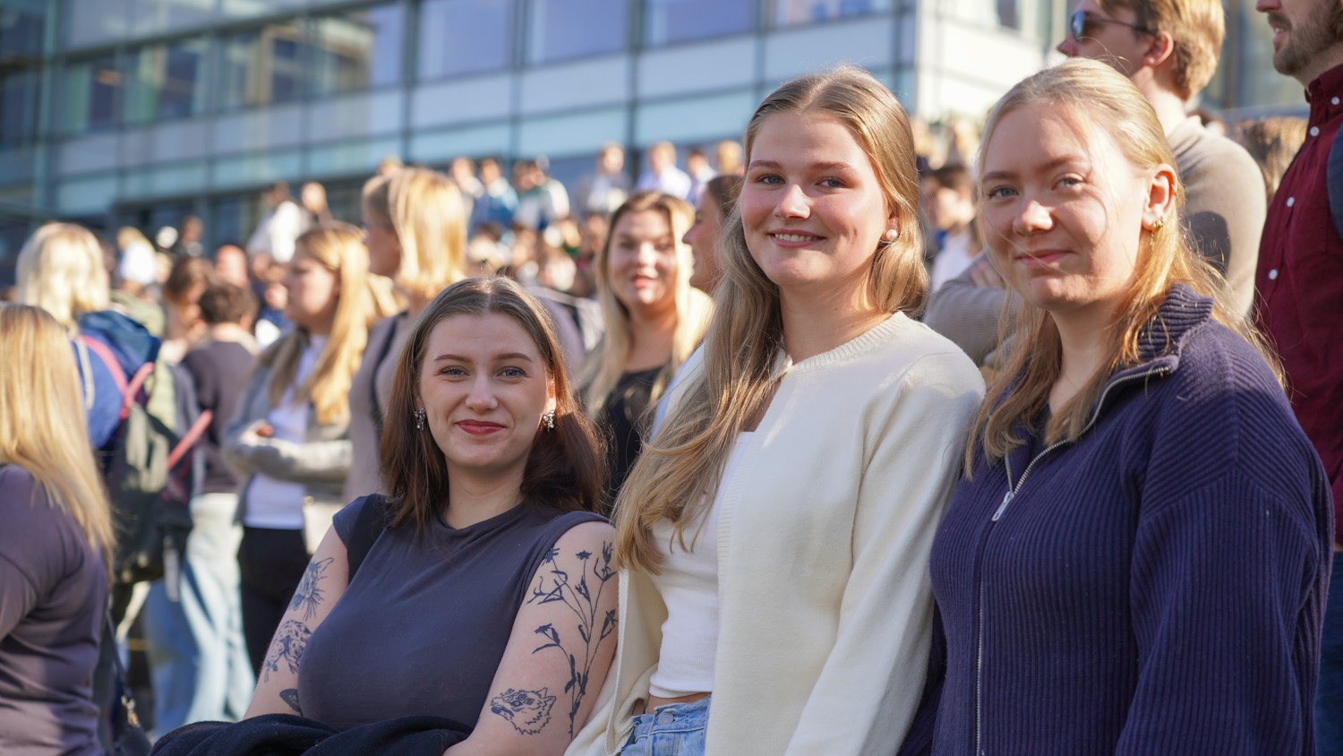 Tre jenter i en folkemengde under åpningen av stuideåret ved campus Lillehammer.