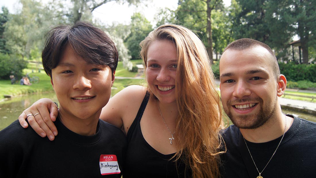 Tre internasjonale studenter i parken. 