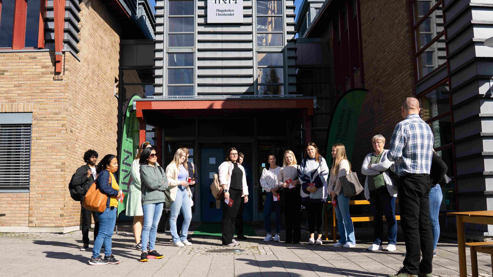 Studenter står utenfor hovedinngangen til studiested Rena.