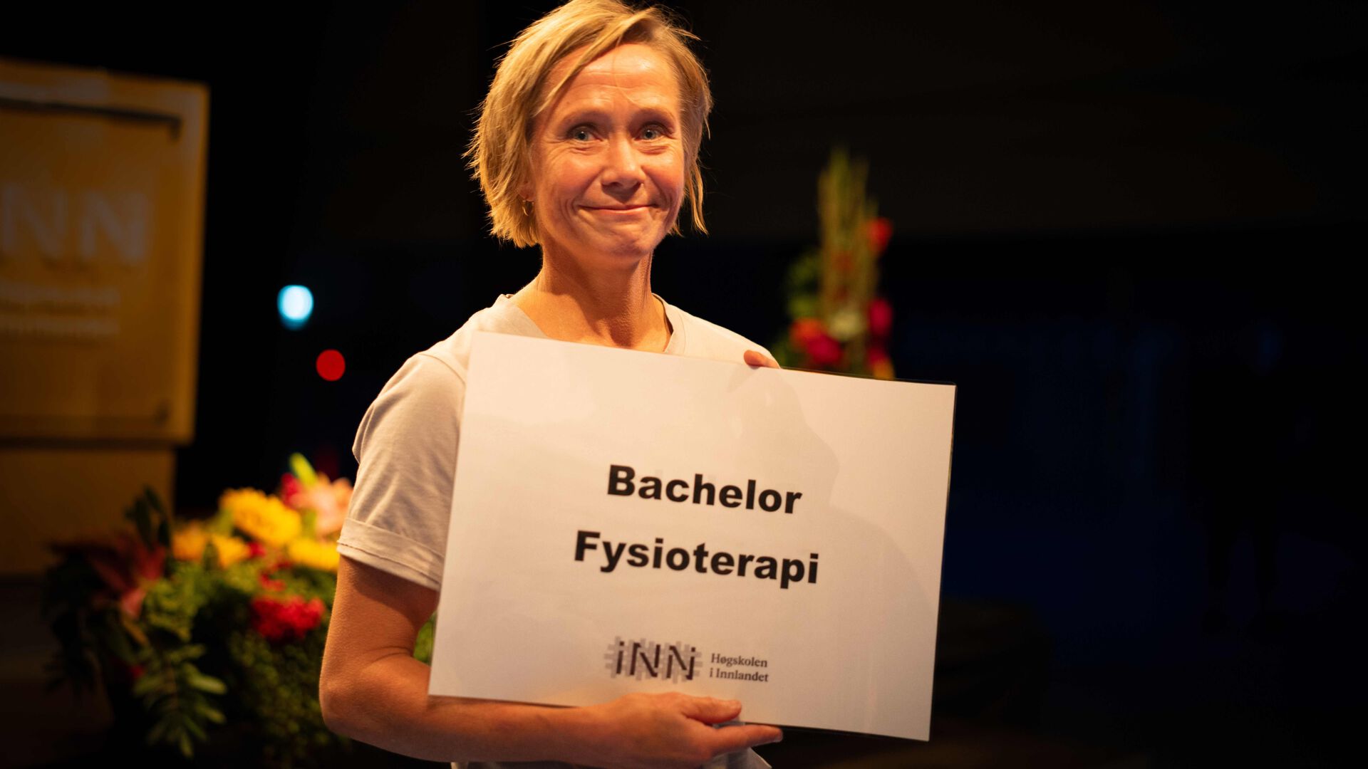 Dame holder fram et skilt det står Bachelor Fysioterapi på