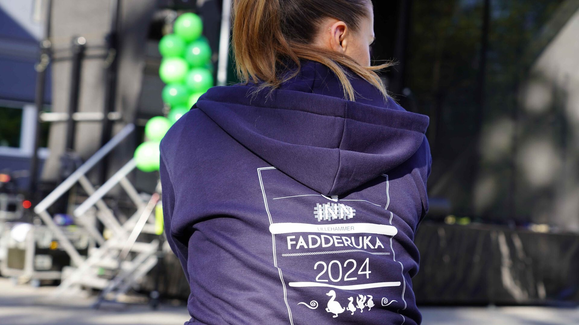 Bilde av ryggen til en student som har på seg en hettejakke med påskriften Fadderuka 2024