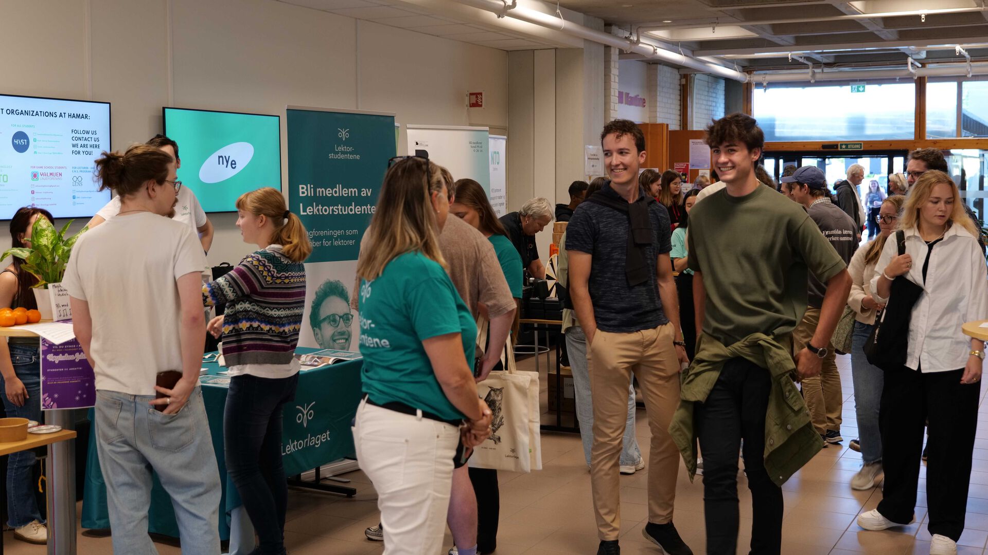 En gruppe studenter studerer informasjon inne på campus Hamar