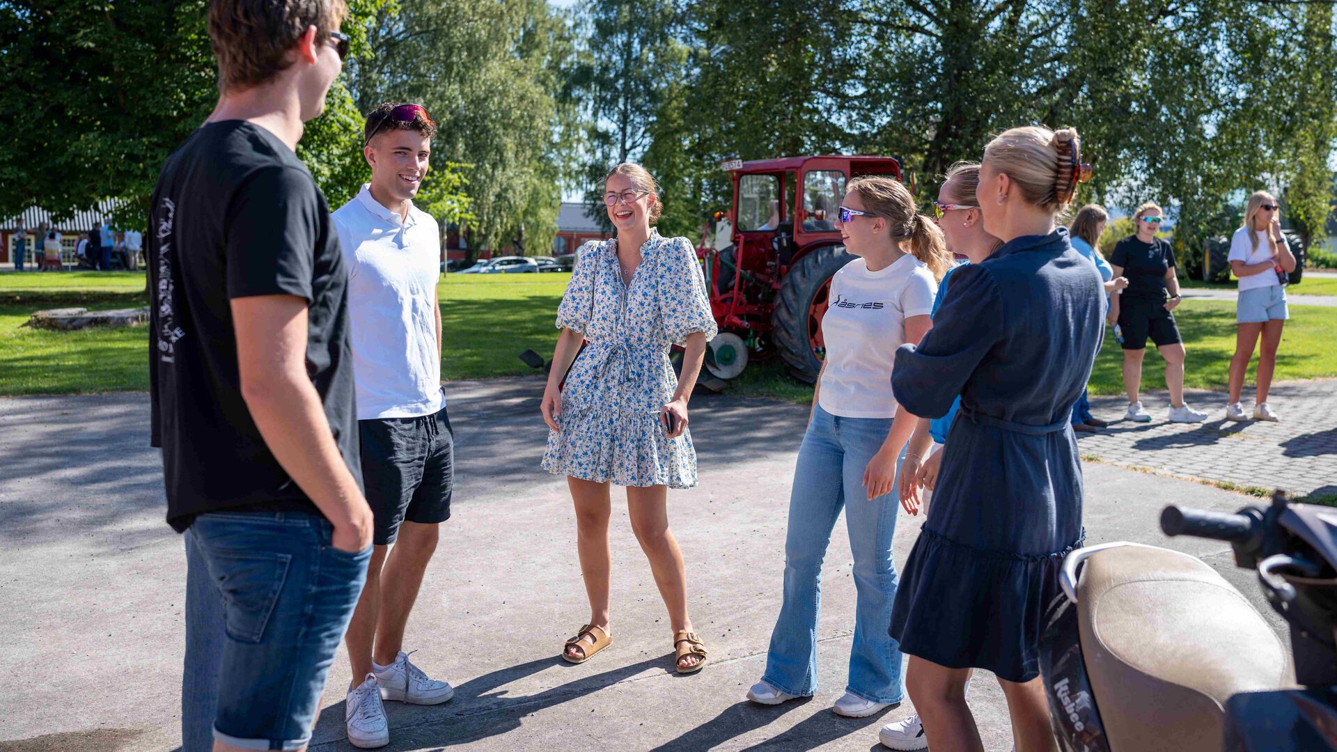 En gruppe på seks studenter står i en ring og prater ute på Blæstad