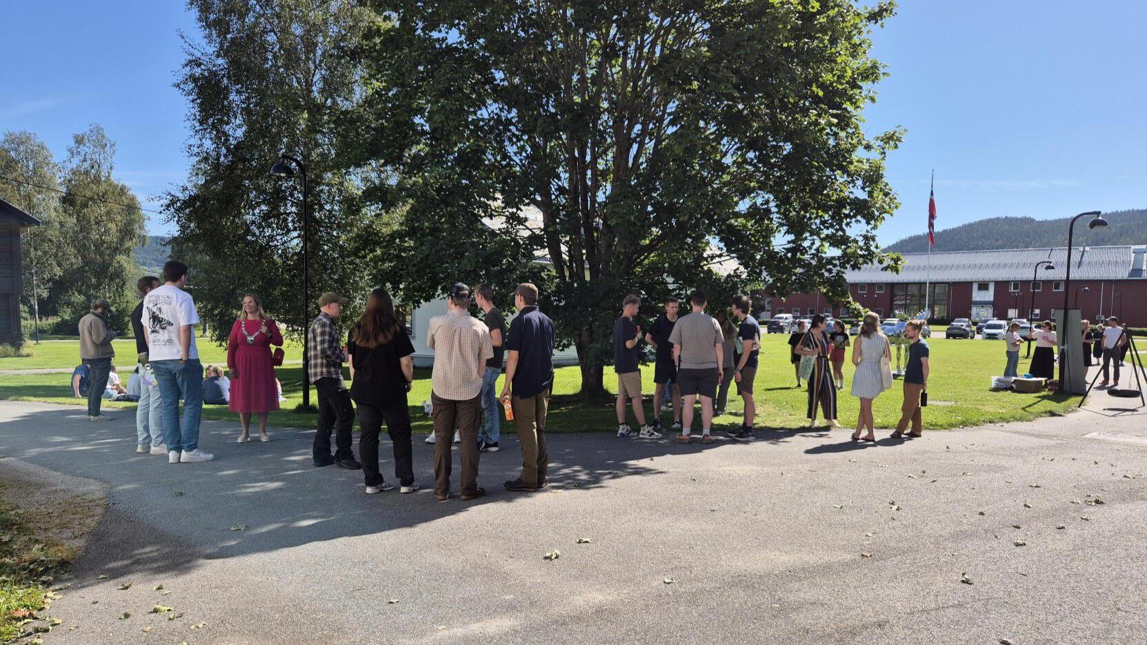 Oversiktsbilde ute Evenstad studenter står og prater ordføreren er også med i bildet