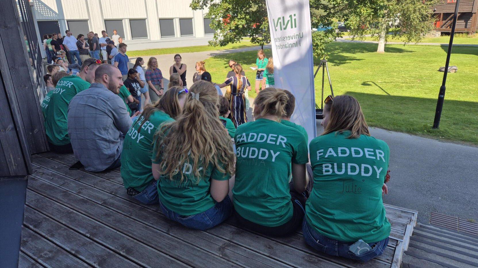 Rygger med t-skjorter med påskrift Fadder Buddy