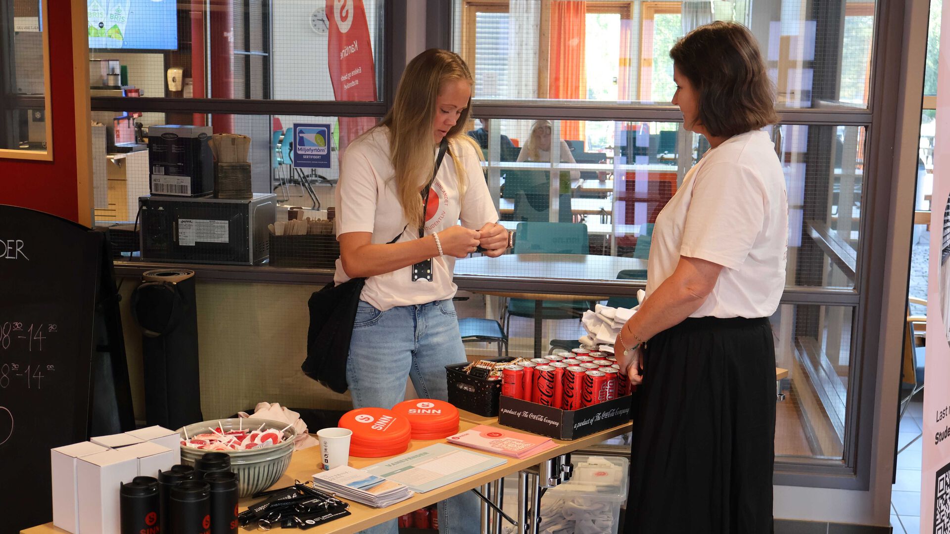 To damer gjør i stand et bord med diverse gadgets til studentene på Rena
