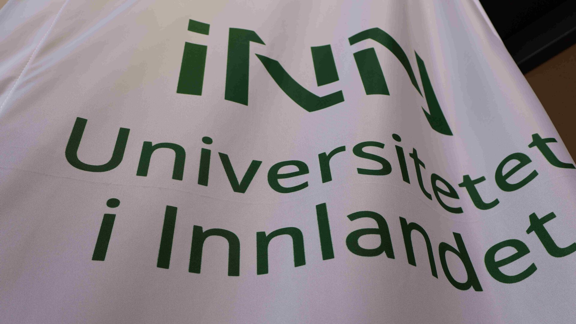 Nærbilde av banner med logoen til Universitetet i Innlandet