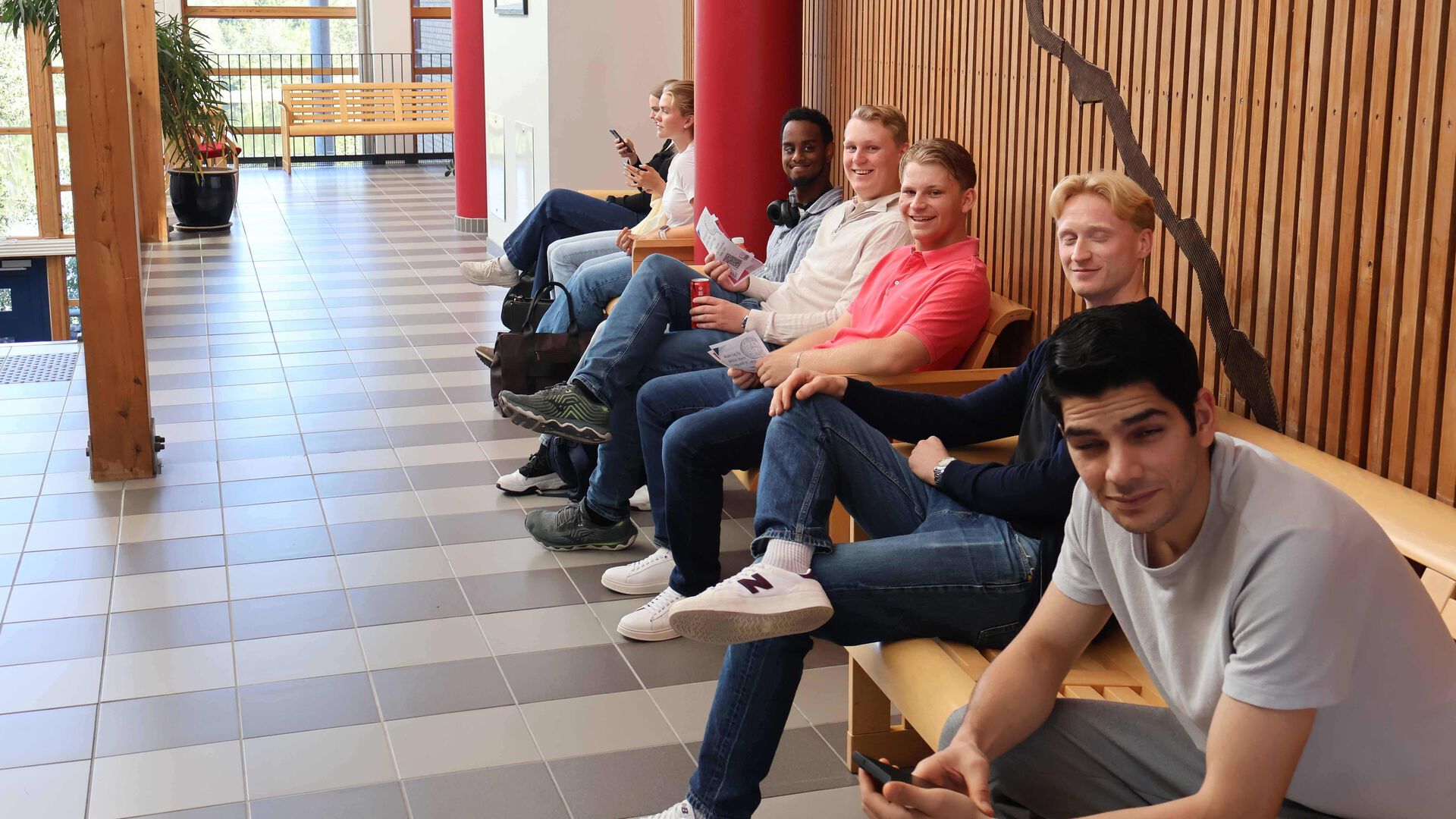 En rekke med mannlige studenter sitter og venter.