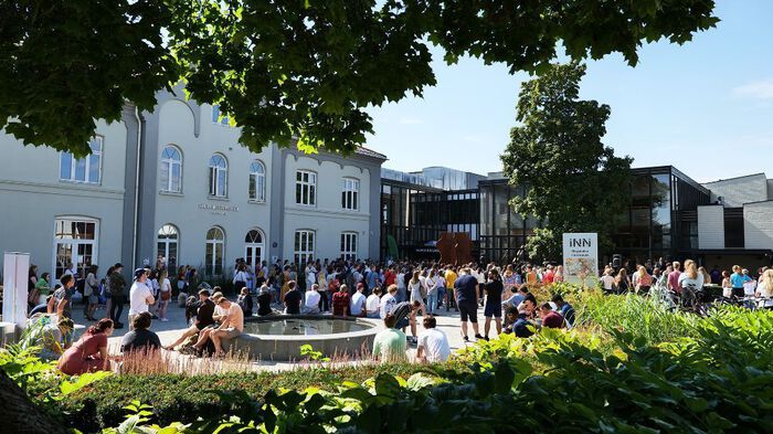 Bilde av studenter utenfor høgskoles bygninger i Hamar