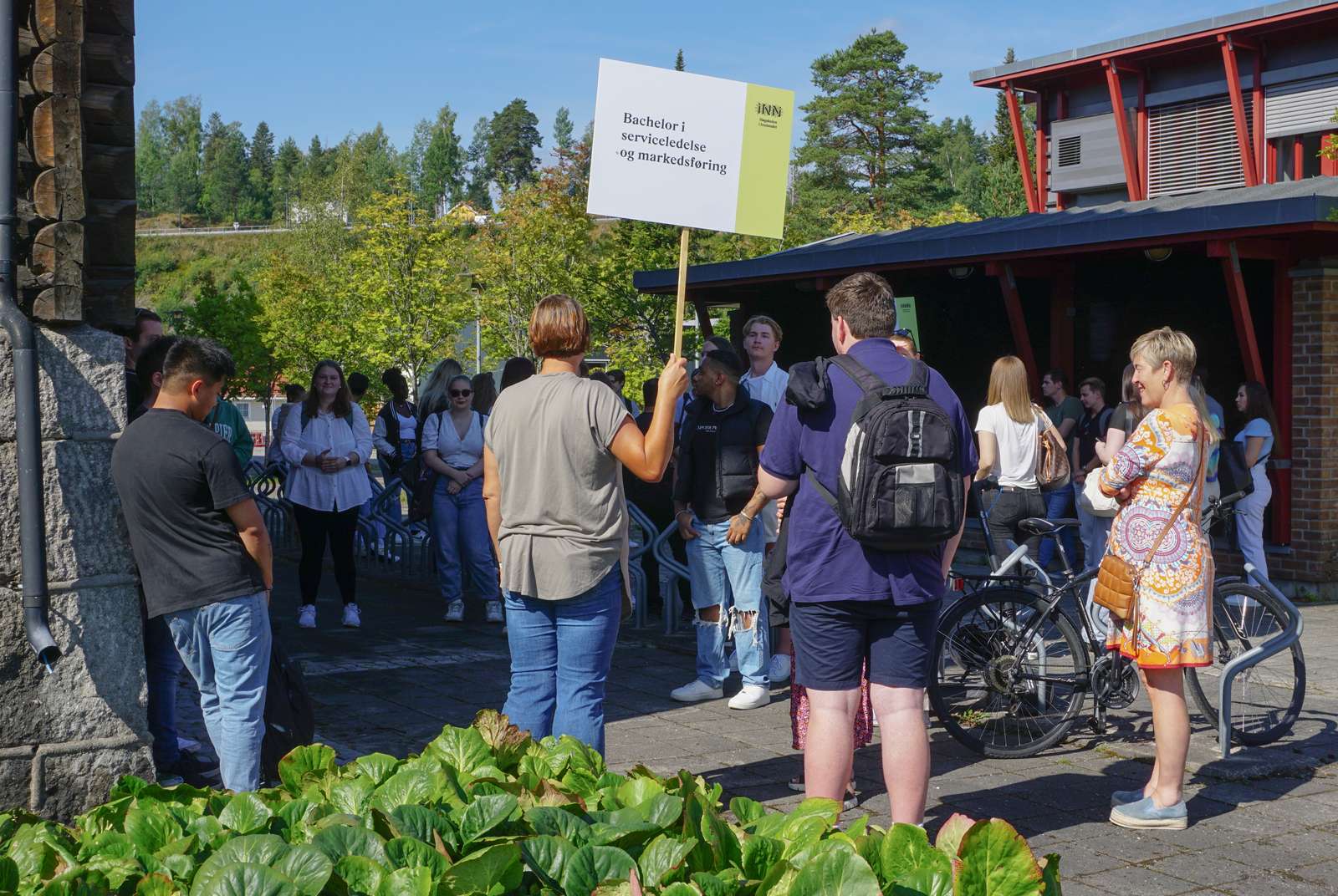 Studenter i flokk utenfor hus