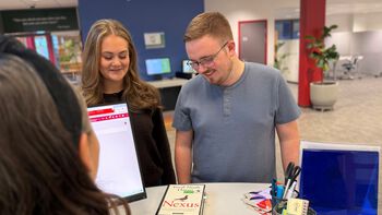 To studenter står ved biblioteksskranken