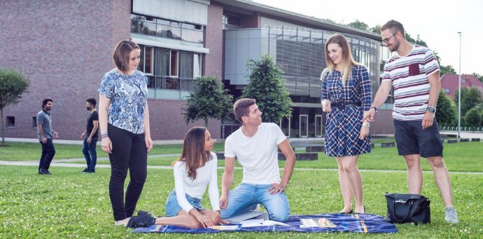 Studenter på plenen foran høgskolen