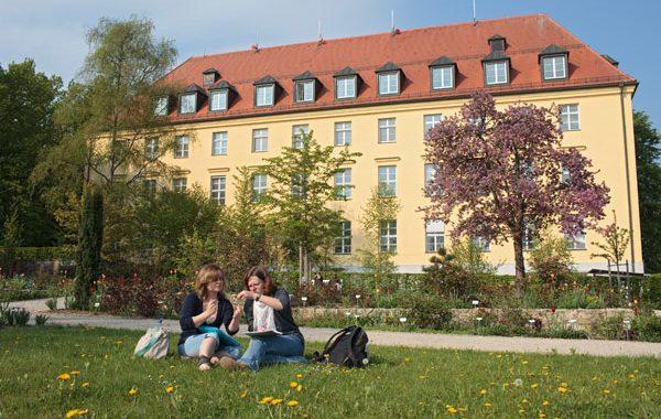 Studenter på plenen foran hovedbygningen