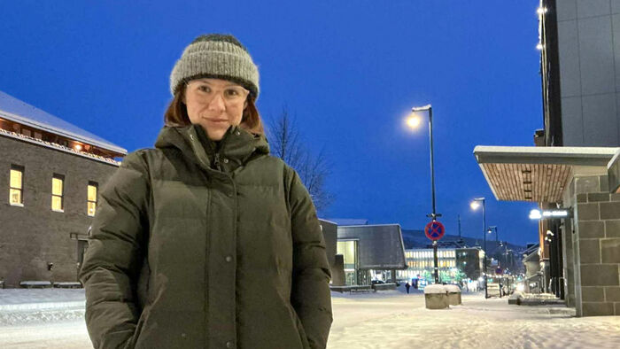 Dame med lue og vinterjakke ute på gata i LIllehammer en kald kveld