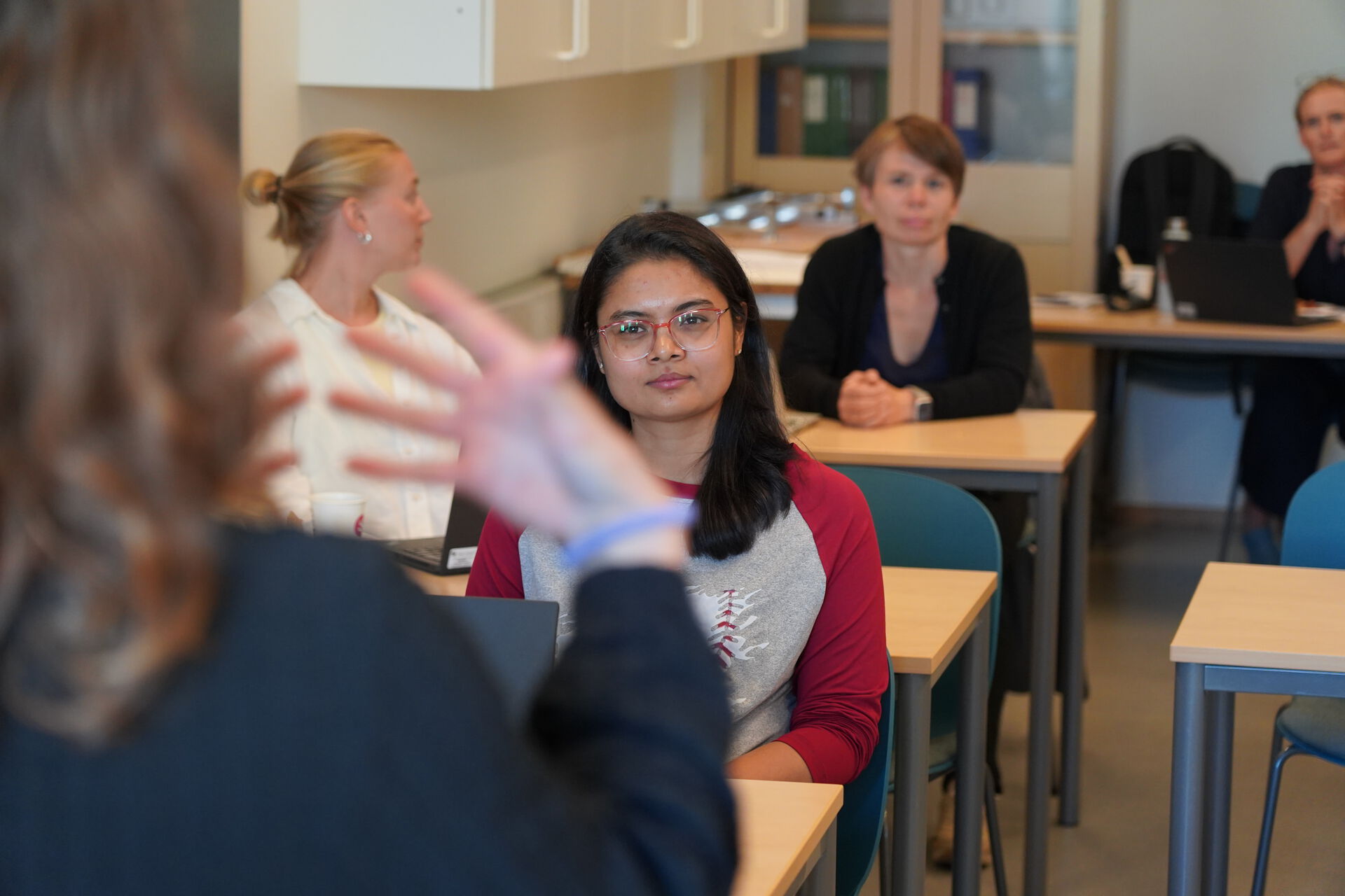 Folk følger med på undervisning i et klasserom