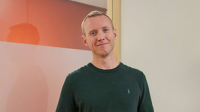 Patrick foran en hvit og rød vegg
