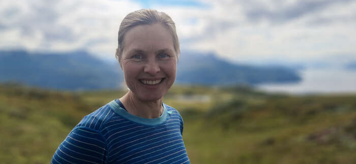 Dame med blå ulltrøye i fjellet