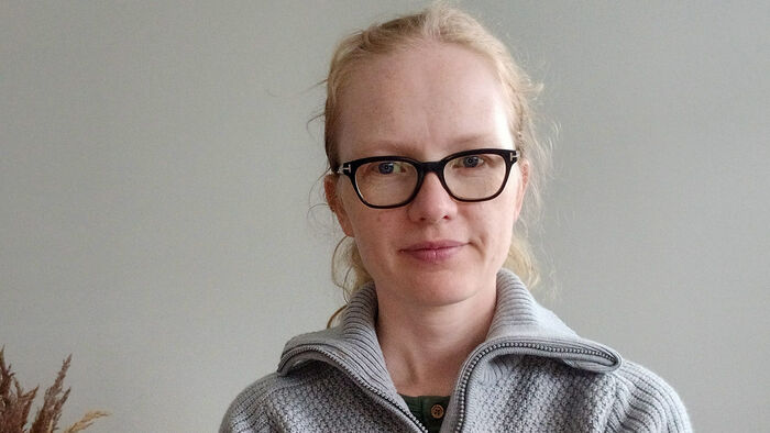 Ung dame med briller og grå ullgenser