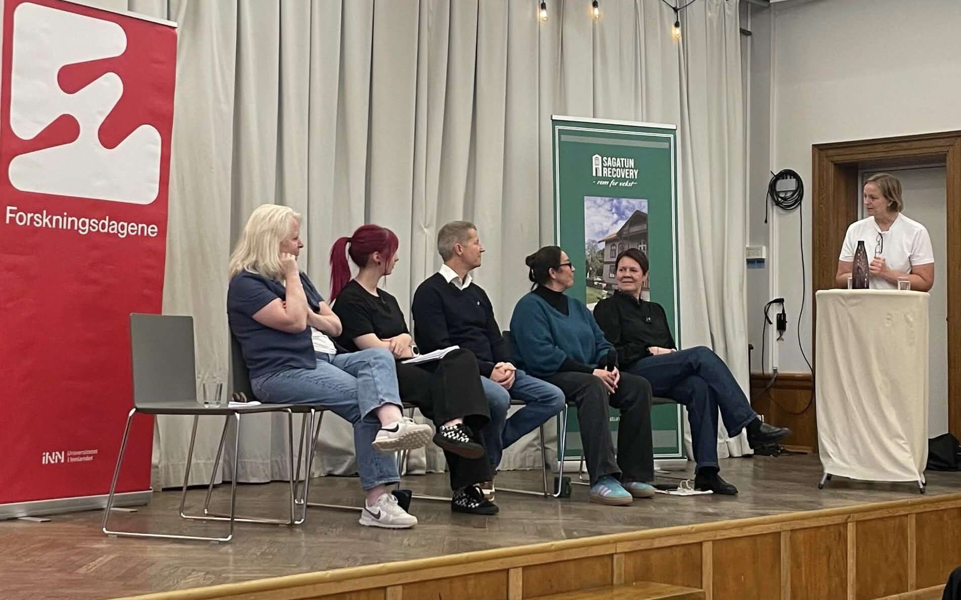 Fem personer i en panelsamtale på en scene