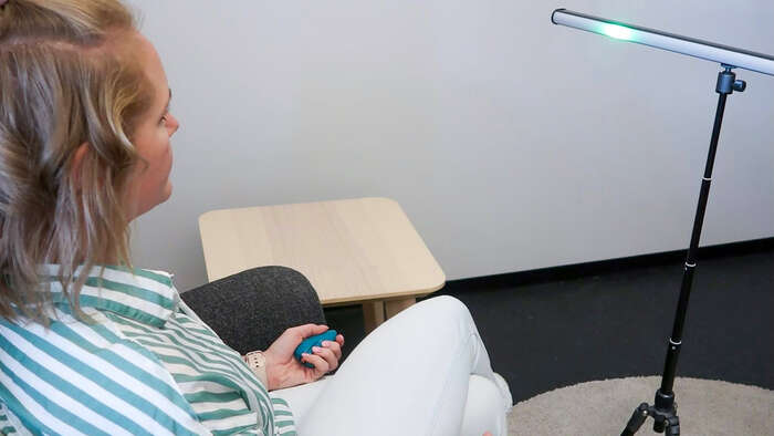 Bilde av hender til noen som sitter i en sofa