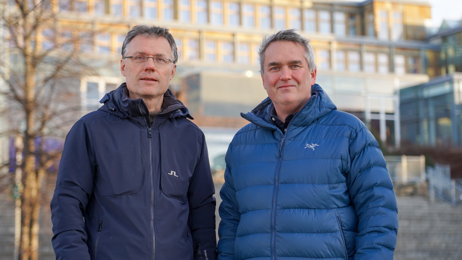 Kjell og Trond med vinterjakker ute foran bygningen på campus LIllehammer