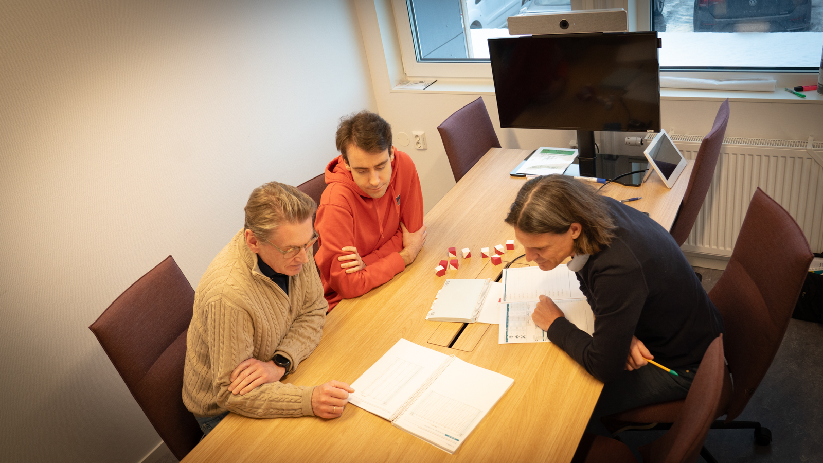 Stian, Per and Erik seen from above while sitting a a table in an  office