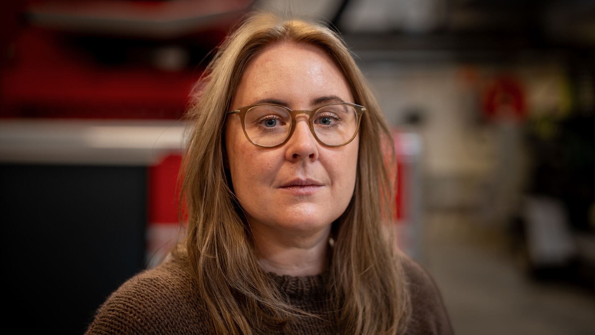 Portrettbilde av dame med brunt hår og briller