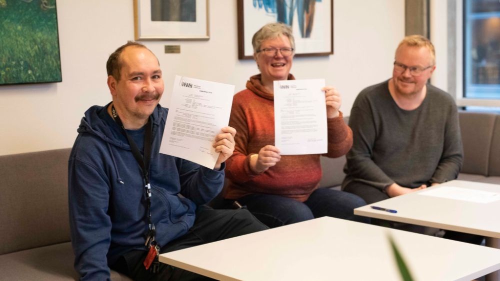 Bilde av tre personer som har skrevet under arbeidskontrakt