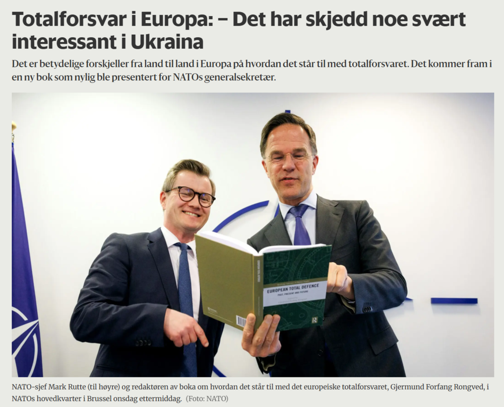 En forsker sammenb med sjef for Nato som holder en bok i hendene 