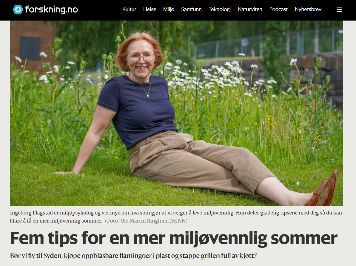 En kvinnelig forsker sitter i gresset mot en blomstereng