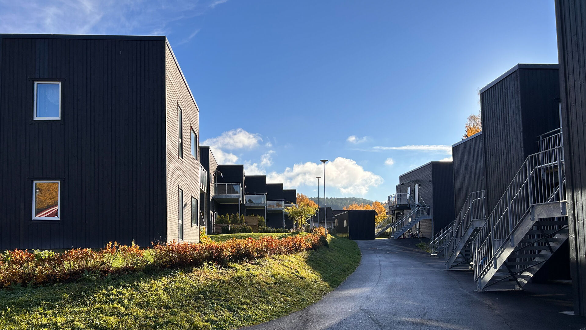 Brune hus i rekke med vei i mellom