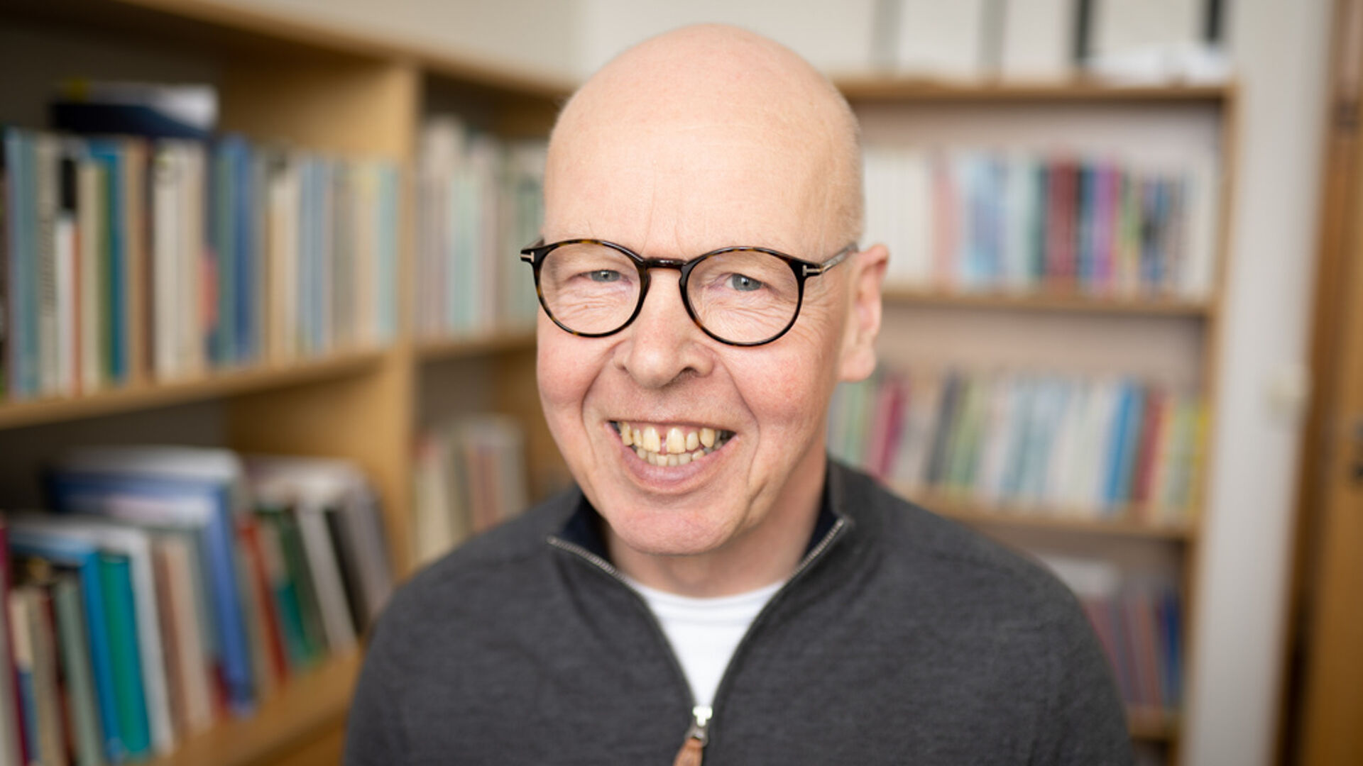 Mann smiler i kamera inne på et kontor