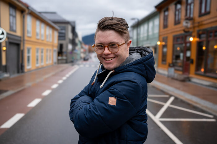 Portrettbilde av en blid Eirik midt i gata i Lillehammer sentrum.