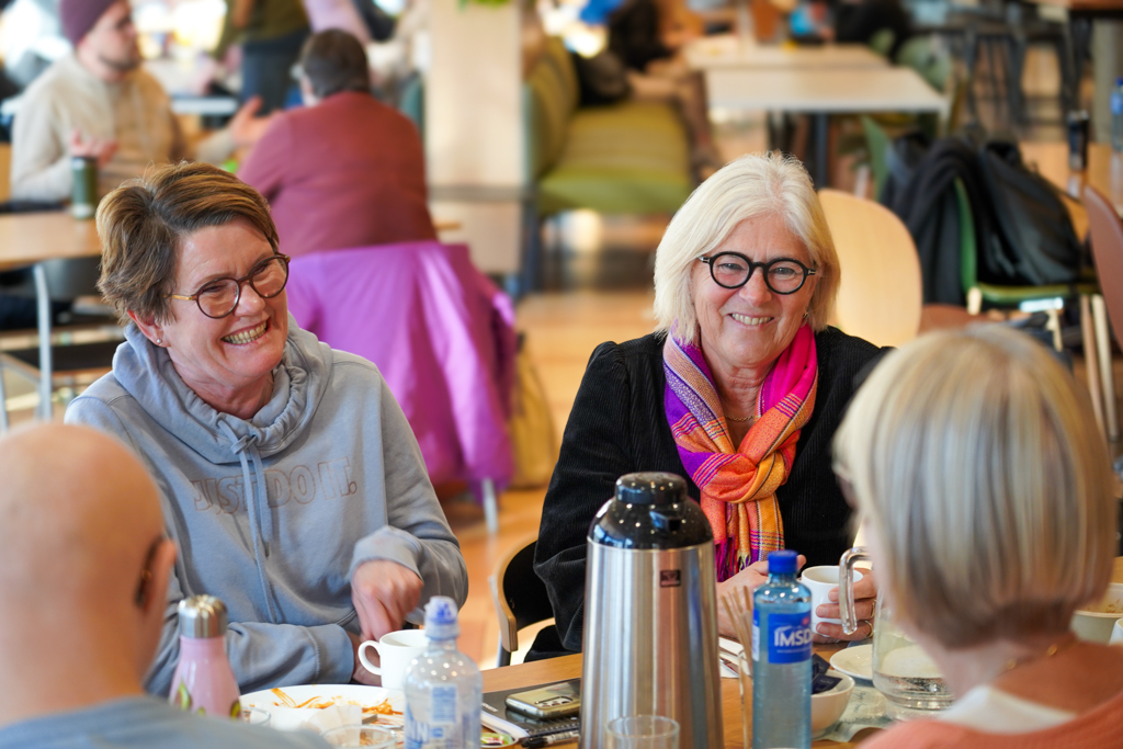 Mor Torill og forsker Anne Stine i munter samtale rundt lunsjbordet.