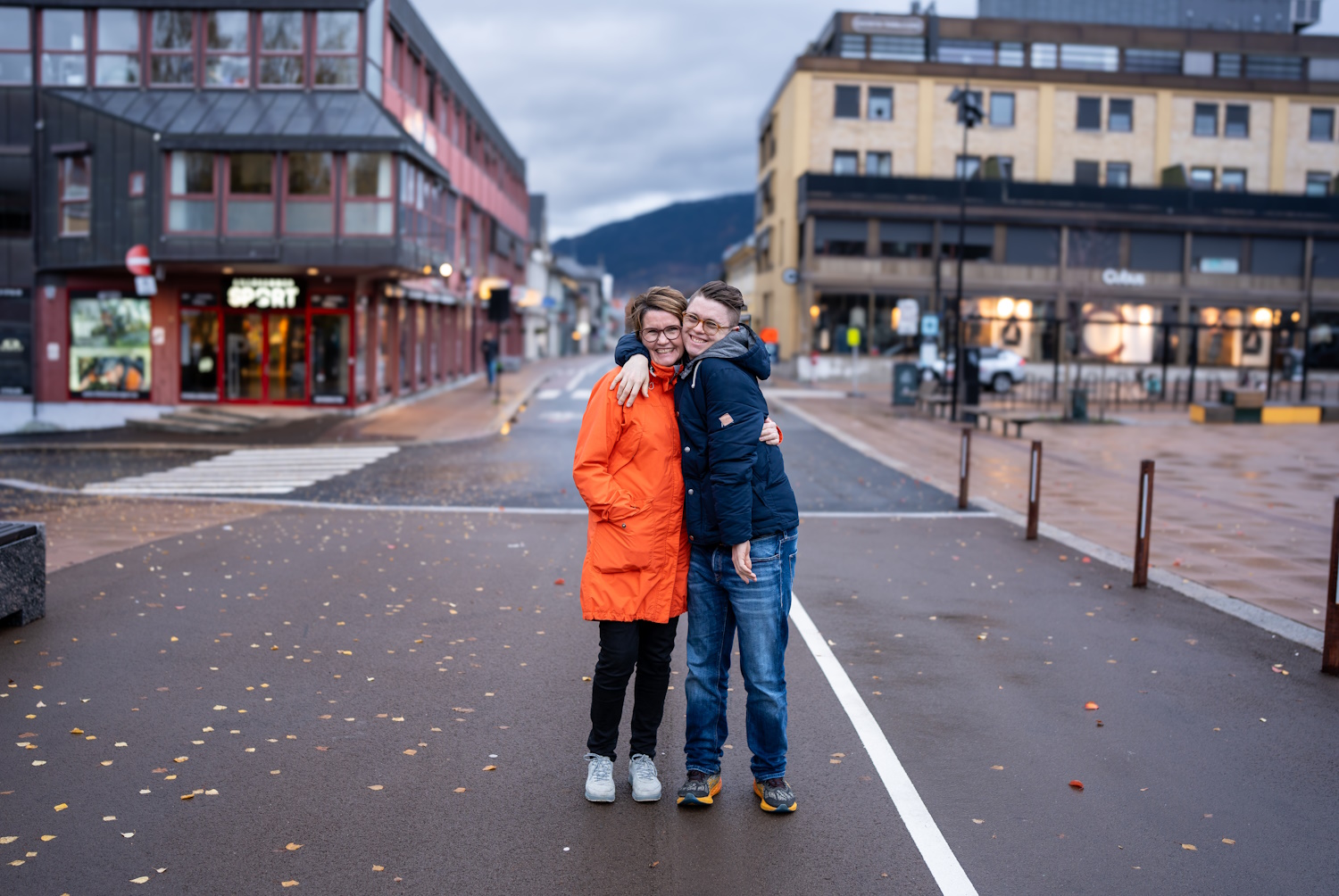 Mor Torill og sønn Eirik som holder rundt hverandre og smiler i kamera midt i gaten på Lillehammer.