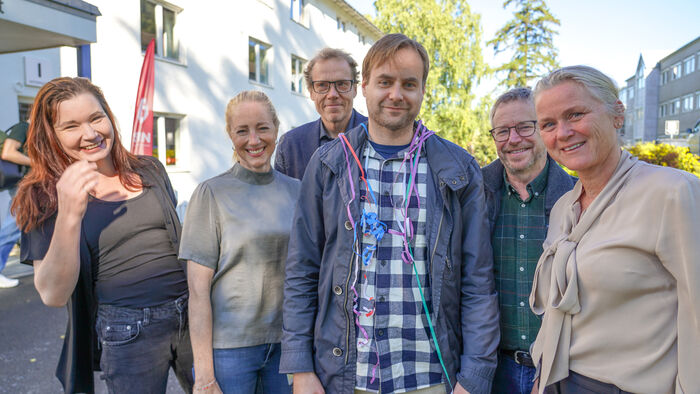 Olav Vassend omgitt av sjefer og kollegaer med pynt rundt halsen