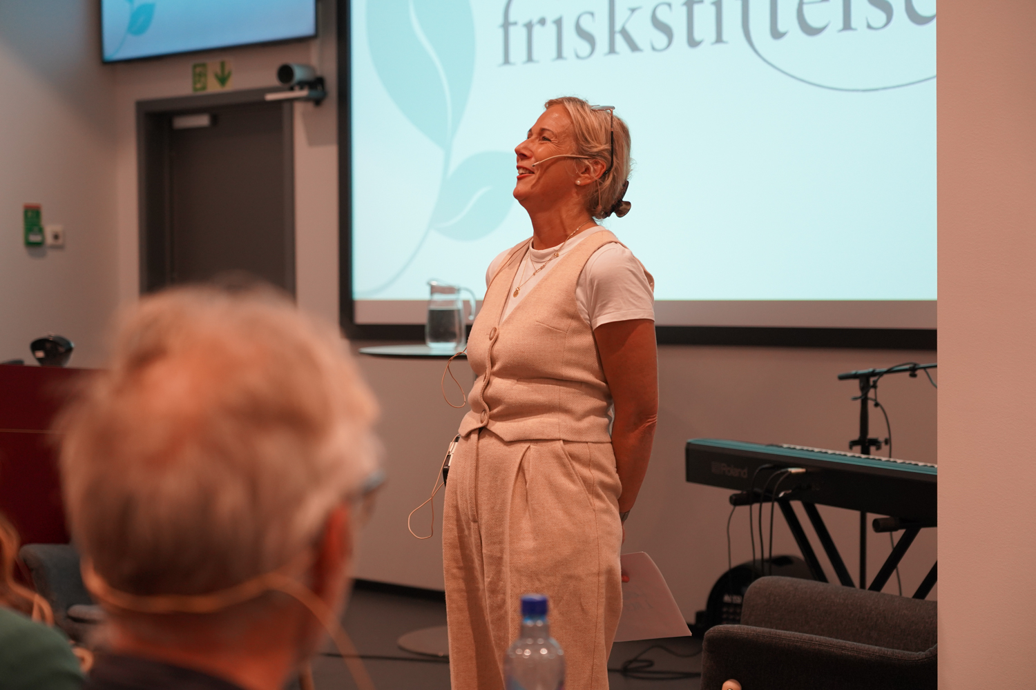 Dame foran publikum i et auditorium