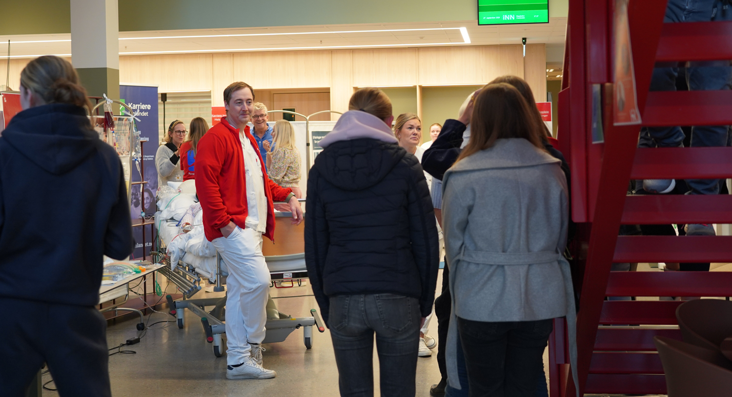 Folk i et rom med en ambulansemann i midten