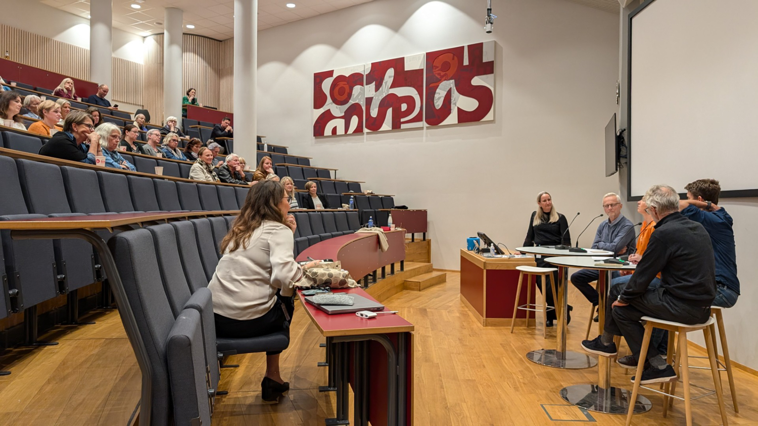 Folk foran publikum i et auditorium