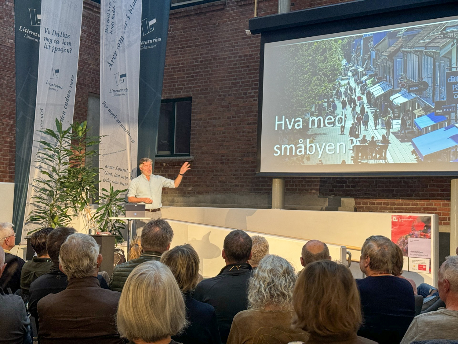 Mann holder foredrag på scene på biblioteket i Lillehammer