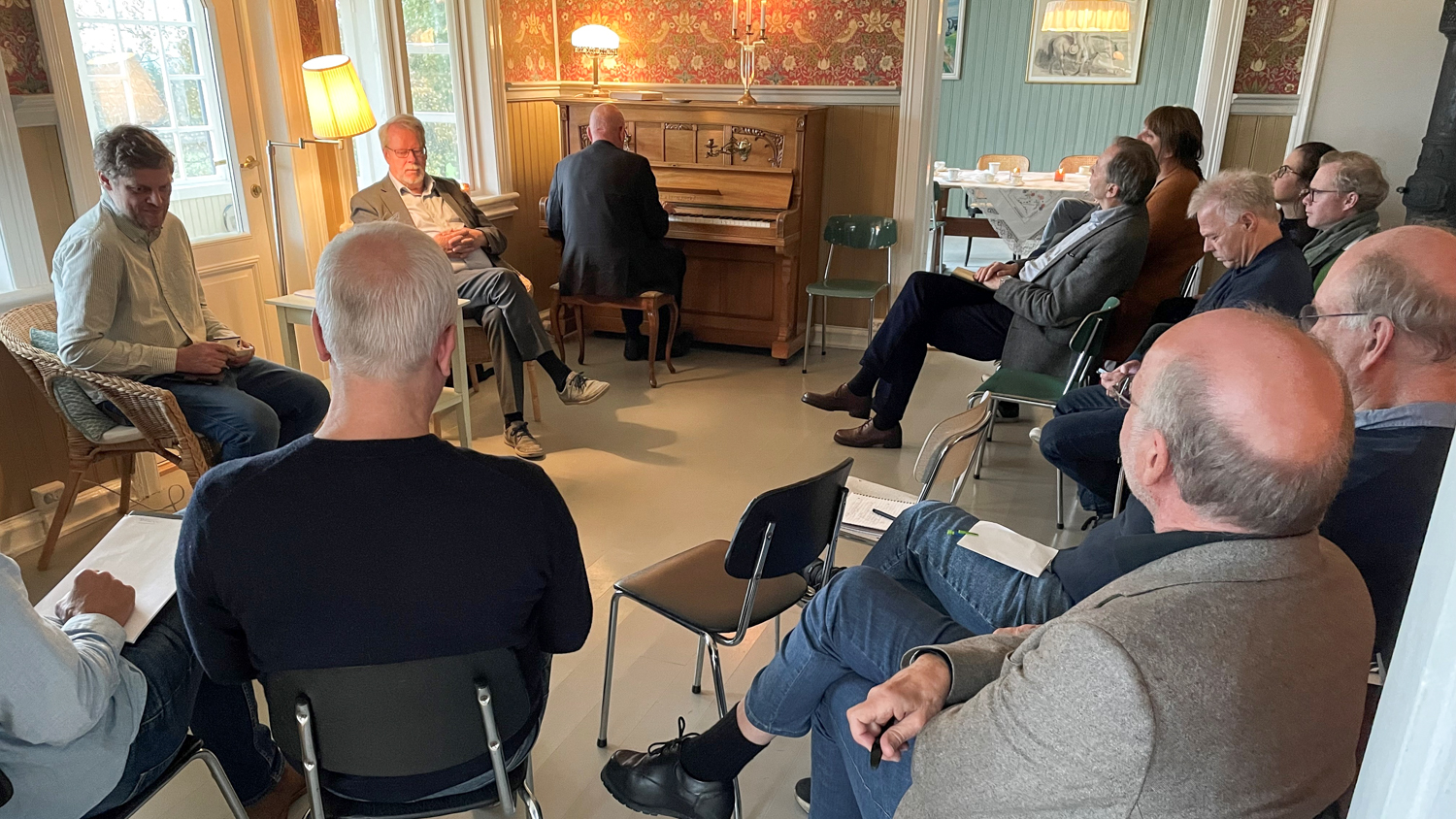 Masse folk inne i et staselig rom med store vinduer
