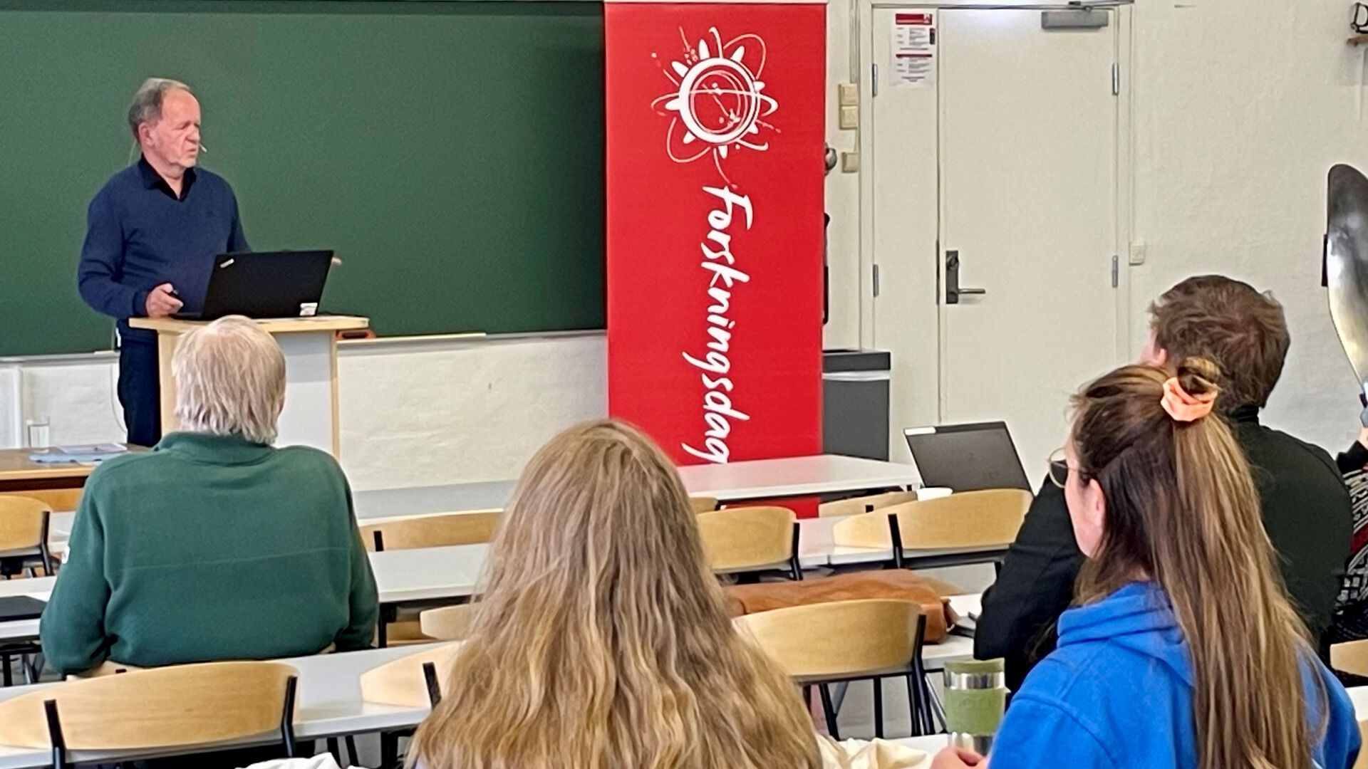 Mann på en talerstol i et auditorium
