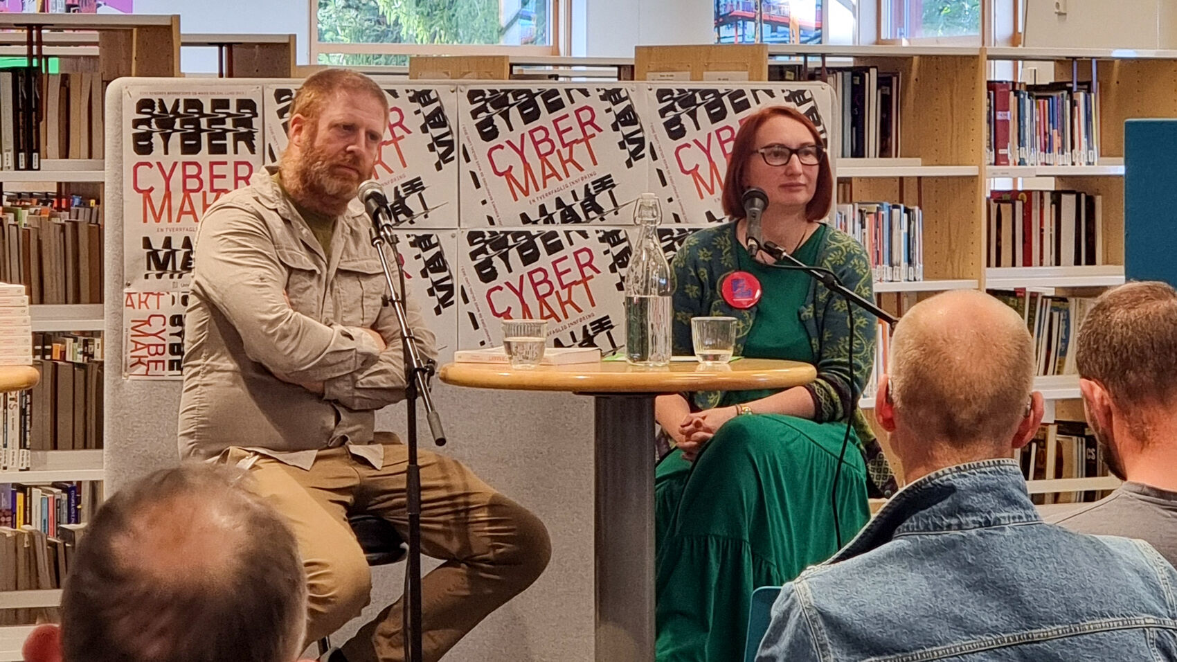 Mann og dame sitter foran et publikum