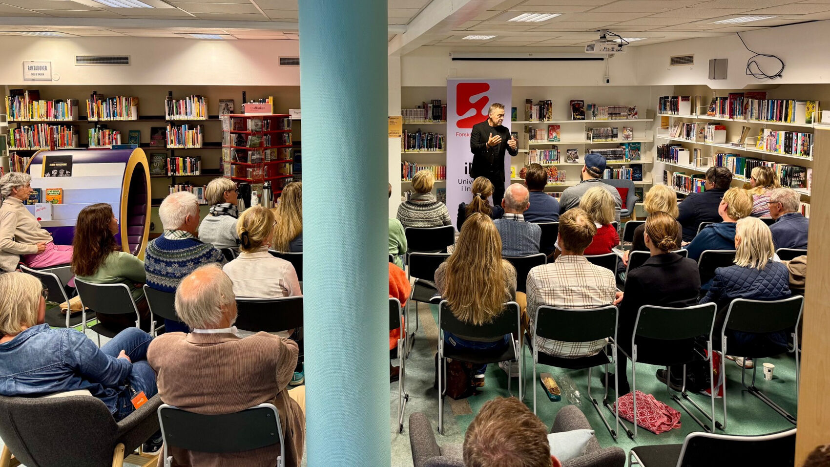 Mann foran publikum i et bibliotek