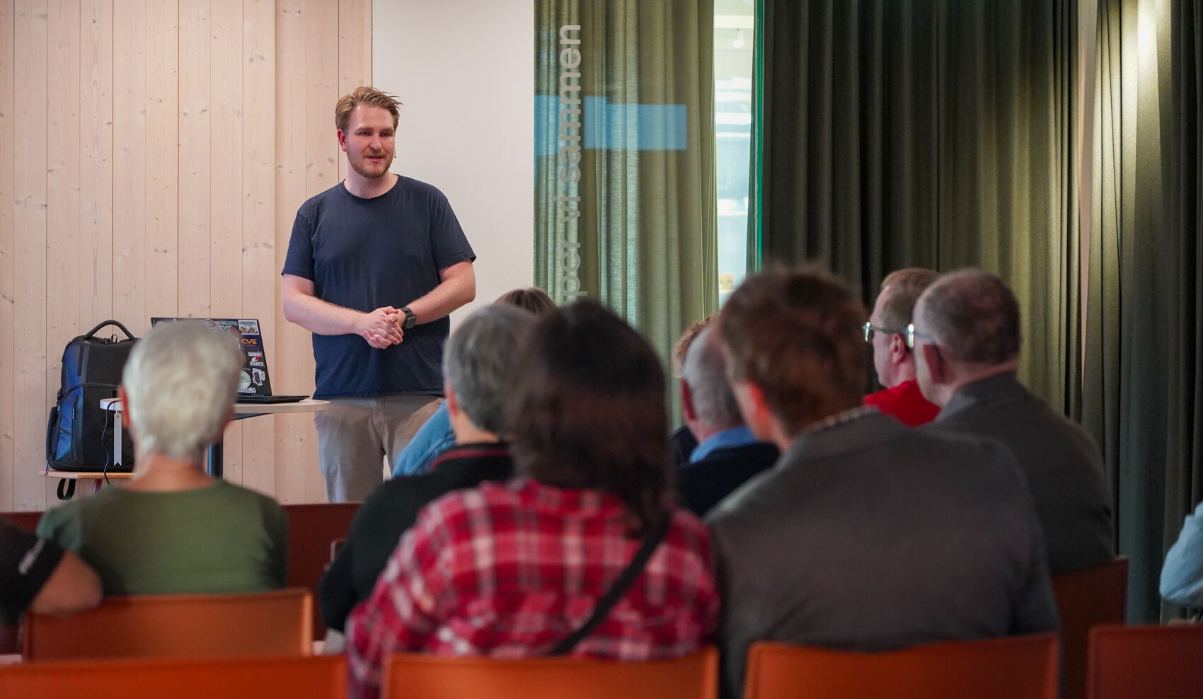 Mann står foran publikum og snakker
