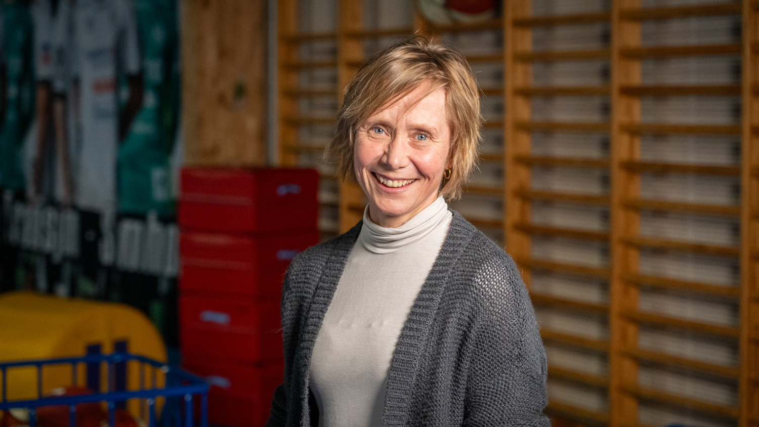 Bilde av Linda Røset mot en ribbevegg i en gymsal