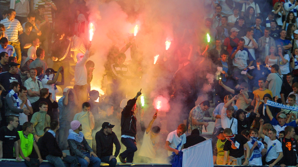 Jublende supportere med bluss på en fotballstadion